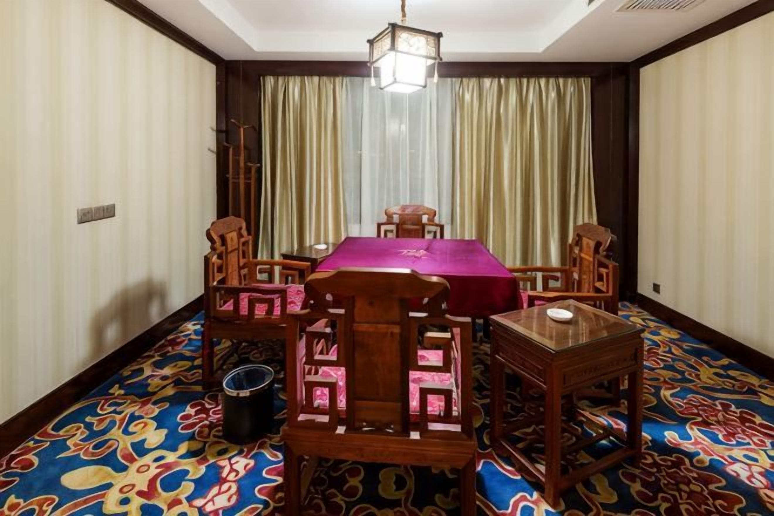 Un comedor con mesa, sillas y alfombra estampada.
