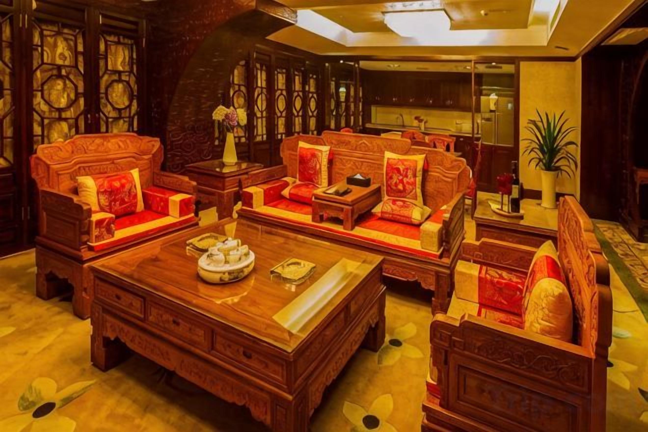 Una sala de estar de estilo tradicional con muebles ornamentados, una mesa de centro y elementos decorativos.