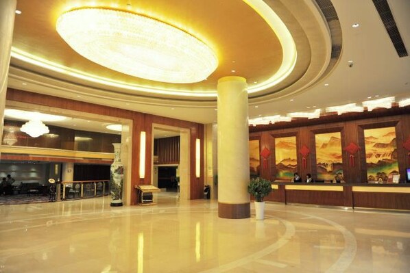 A spacious lobby with a large circular light fixture, a reception desk, and a seating area. - Halcyon Hotel & Resort (Yingtan)