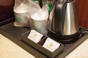 Una encimera de cocina con una tetera, dos botellas de leche y dos sobres de té.