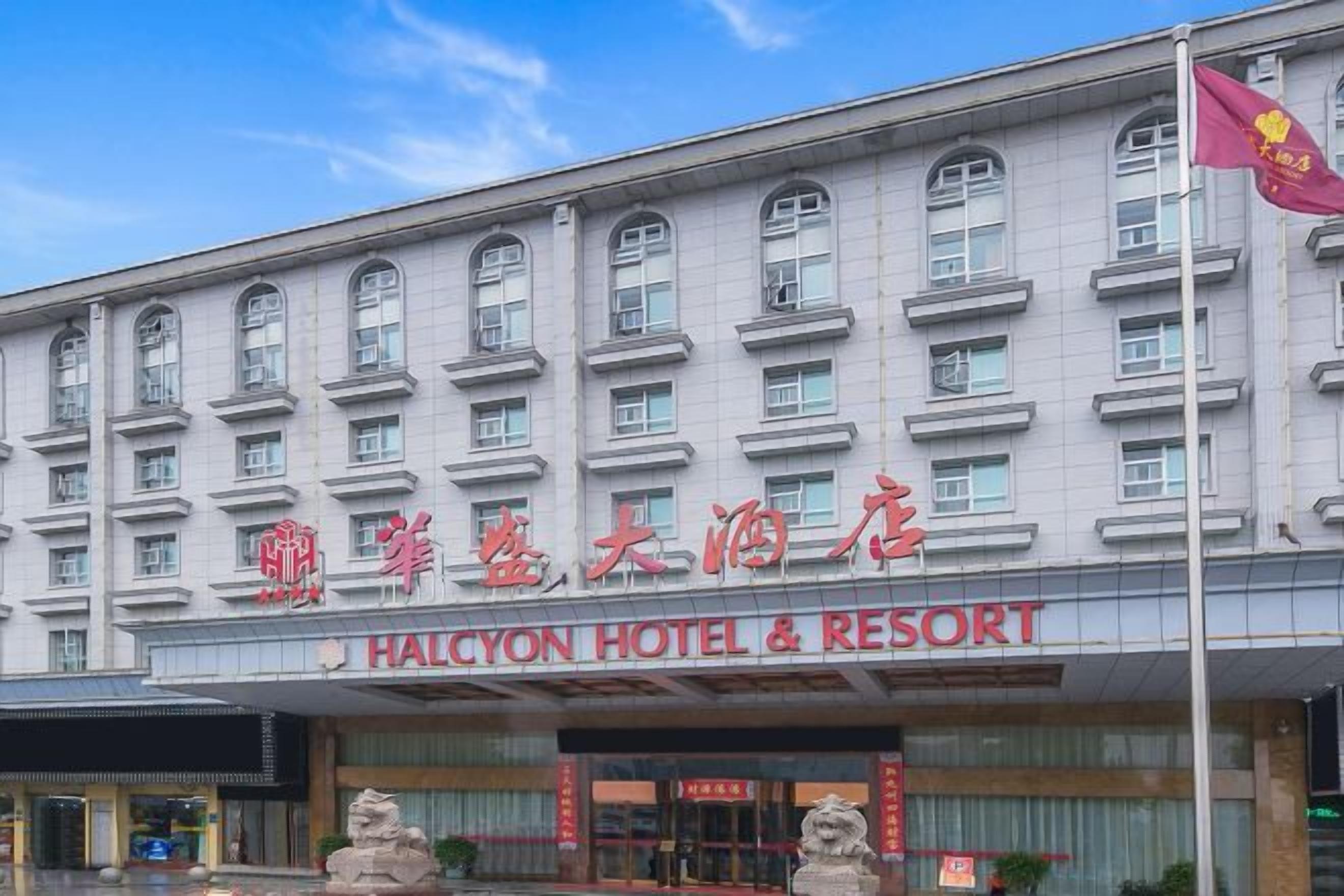 Un hotel de estilo arquitectónico tradicional, con múltiples ventanas y una entrada destacada con señalización.