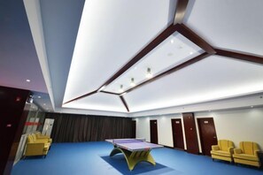 A room with a ping pong table, a blue carpet, and a modern ceiling design. - Halcyon Hotel & Resort (Yingtan)