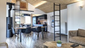 A modern kitchen with a dining area, wooden ceiling, and a sofa in the living room. - Lovely home in Sonlez with sauna (Sonlez)