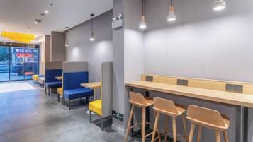 A modern interior with seating areas, tables, and pendant lighting.