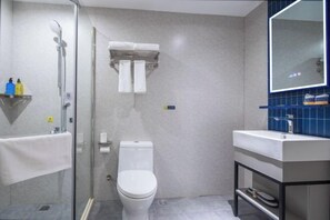 A modern bathroom with a glass shower enclosure, a white toilet, and a sink with a blue tiled backsplash. - 7Days Inn Hotel (Nanjing Lukou Airport) (Nanjing)