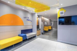 A modern hotel lobby with seating areas, a reception desk, and a QR code for digital services. - 7Days Inn Hotel (Nanjing Lukou Airport) (Nanjing)