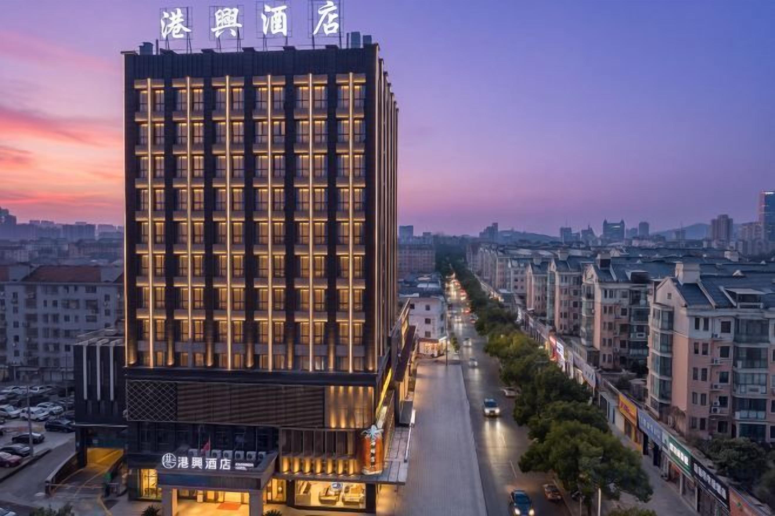 A multi-story hotel with a modern facade, located in an urban setting with a clear view of the street below.