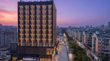 A multi-story hotel with a modern facade, located in an urban setting with a clear view of the street below.