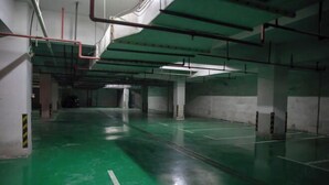 Ένας ευρύχωρος, εσωτερικός χώρος στάθμευσης με πράσινο δάπεδο και βέλη που υποδεικνύουν την κατεύθυνση.