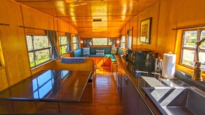 A compact kitchen with wooden cabinets, a central island, and a sink.