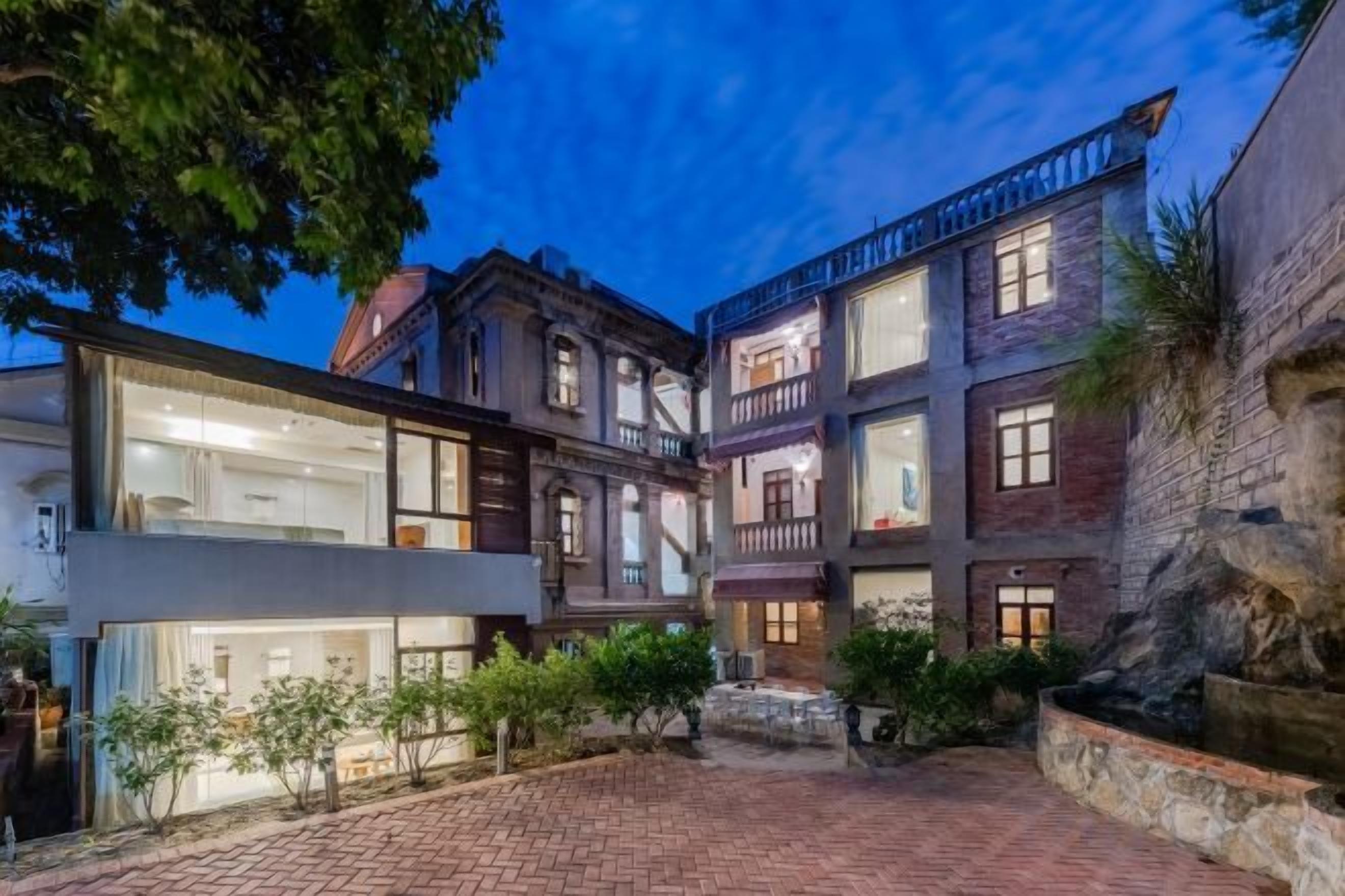 Un edificio de varios pisos con un patio interior, que presenta una mezcla de arquitectura moderna y tradicional.