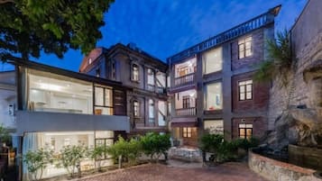 Un edificio de varios pisos con un patio interior, que presenta una mezcla de arquitectura moderna y tradicional.