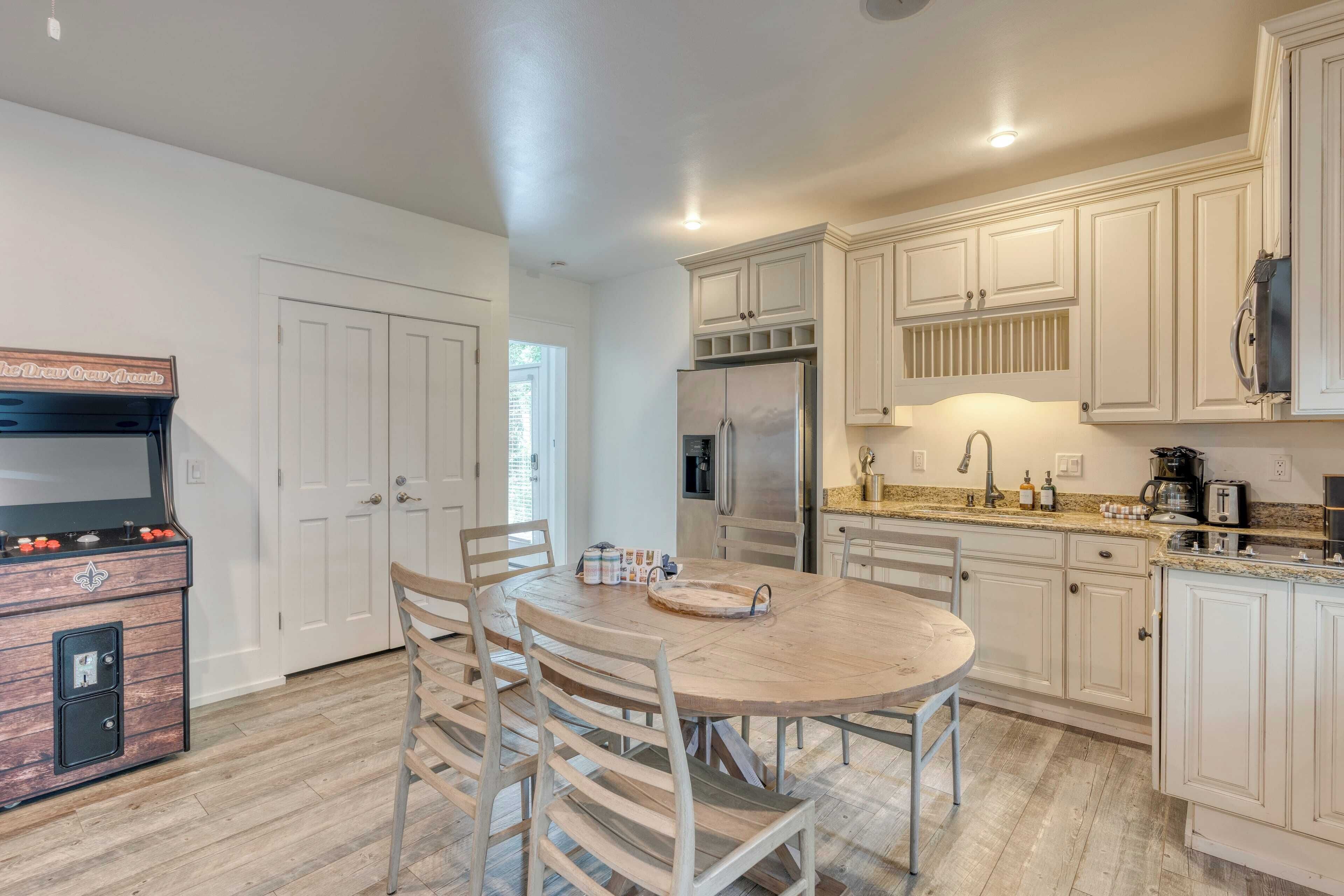 A kitchen with white cabinets, a wooden dining table, and a built-in grill.