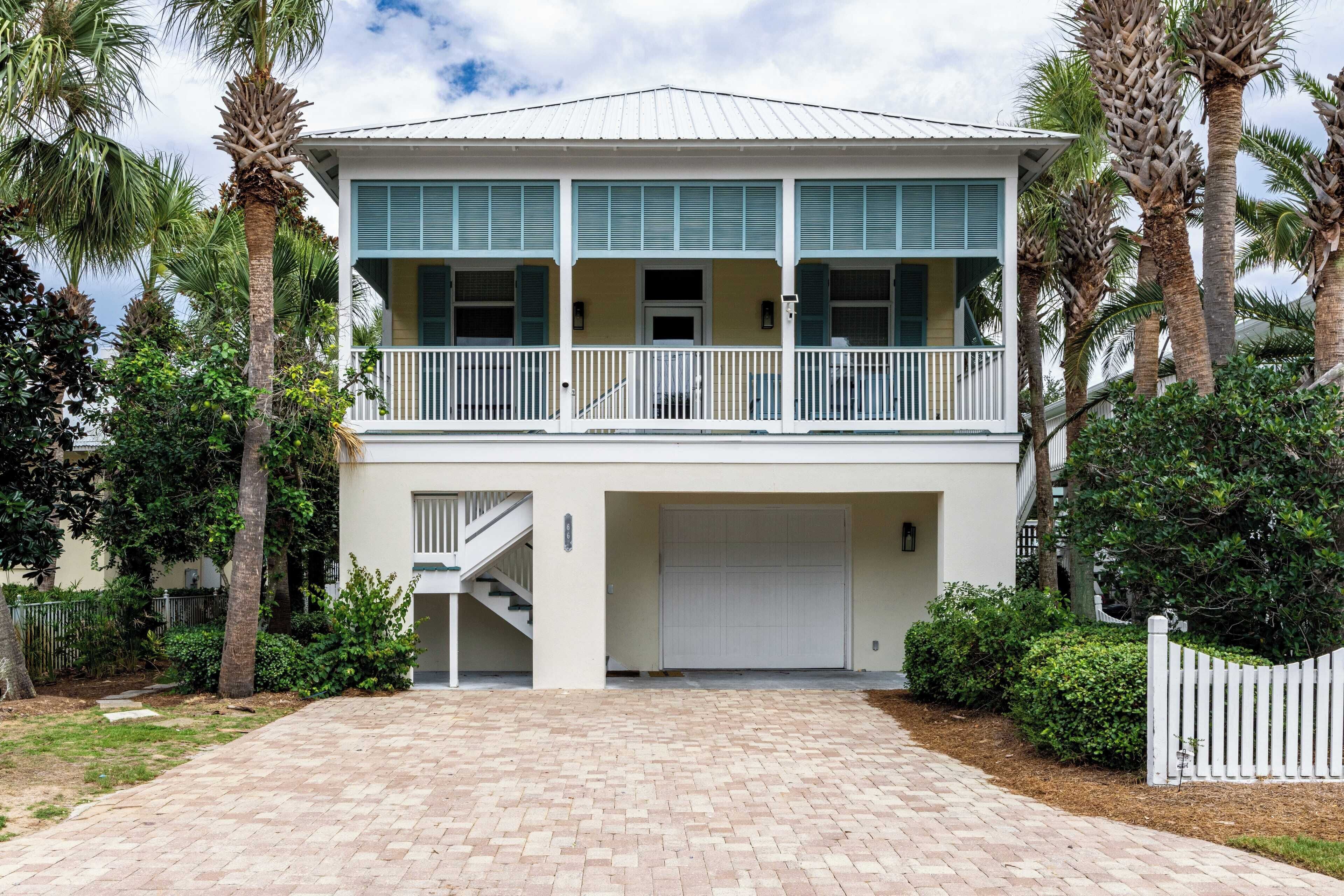 A two-story house with a balcony, a garage, and a driveway.