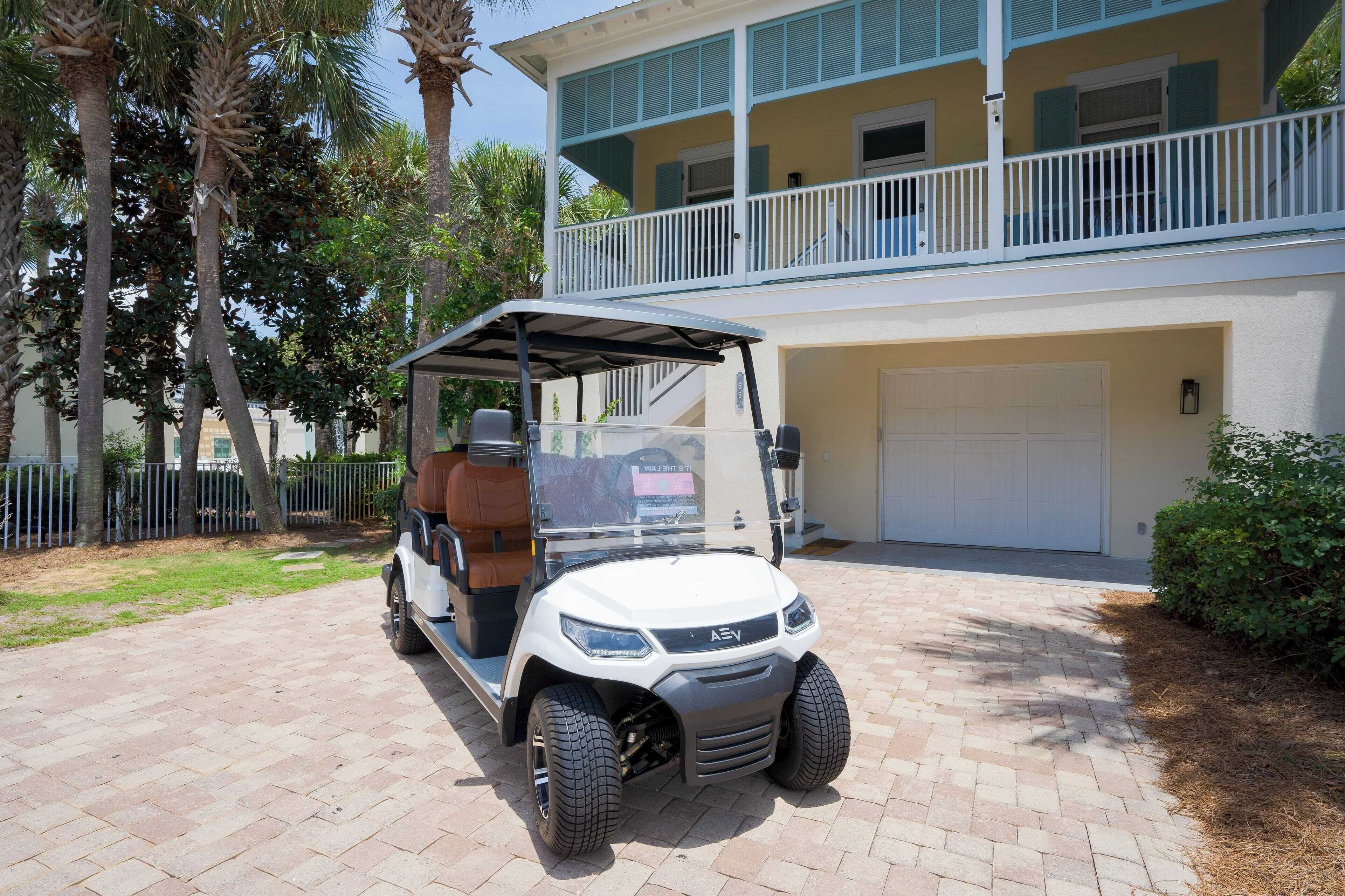 A golf cart parked in front of a two-story building with a balcony.