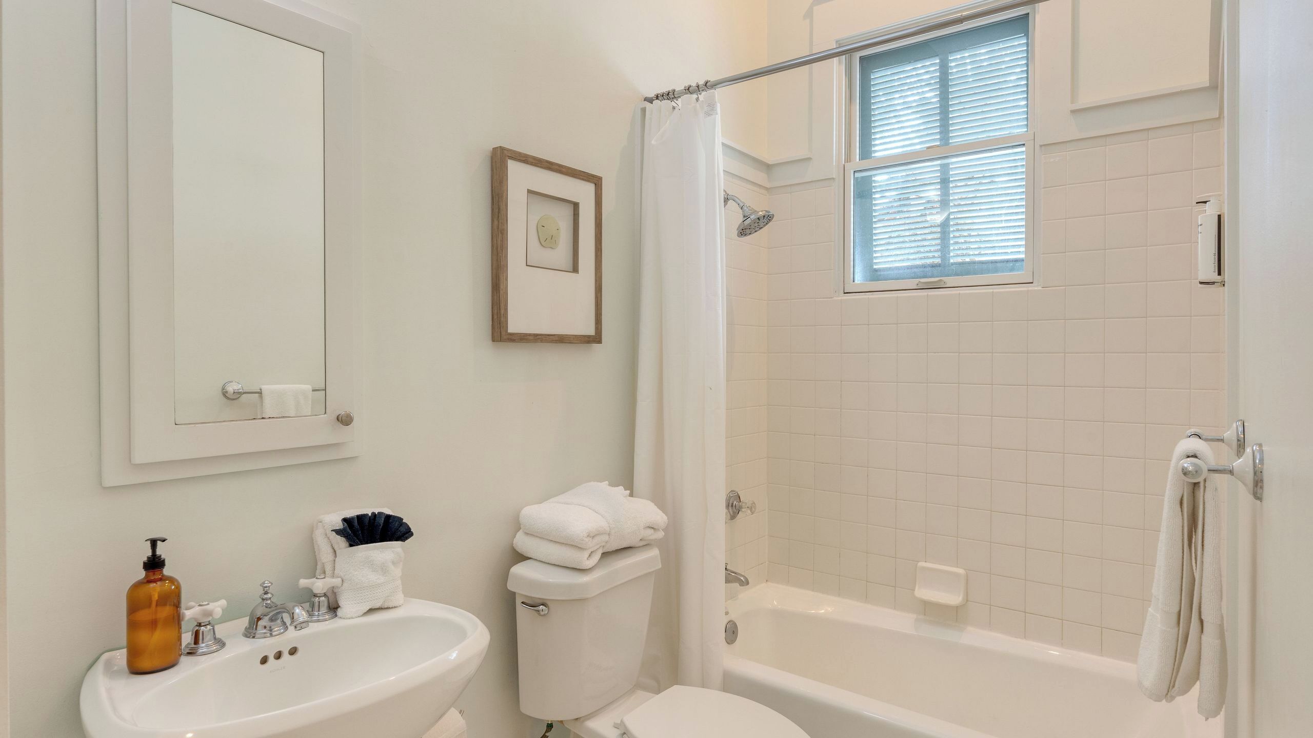 Une salle de bain équipée d’un lavabo, de toilettes, d’une baignoire et d’une douche.