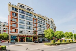 A multi-story hotel with a modern facade, balconies, and a ground-level restaurant. - Blue Sen Hotel (Tiantai Mountain Scenic Area) (Tiantai County)