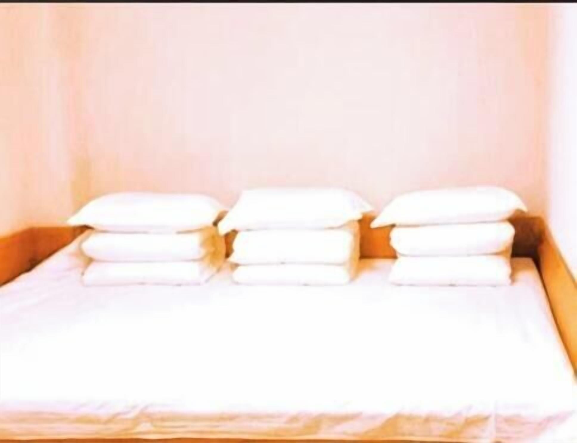 A bed with neatly folded white towels.