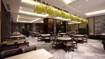 En rymlig hotellobby med flera sittgrupper, en receptionsdisk och ett dekorativt tak.