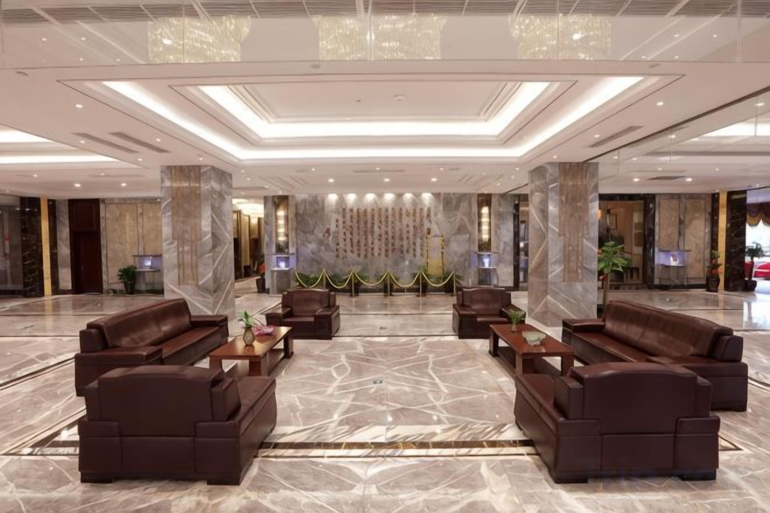 A spacious lobby with a central seating area, a reception desk, and a large wall with vertical lines.