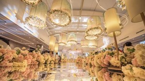 Un vestíbulo amplio con candelabros y arreglos florales.