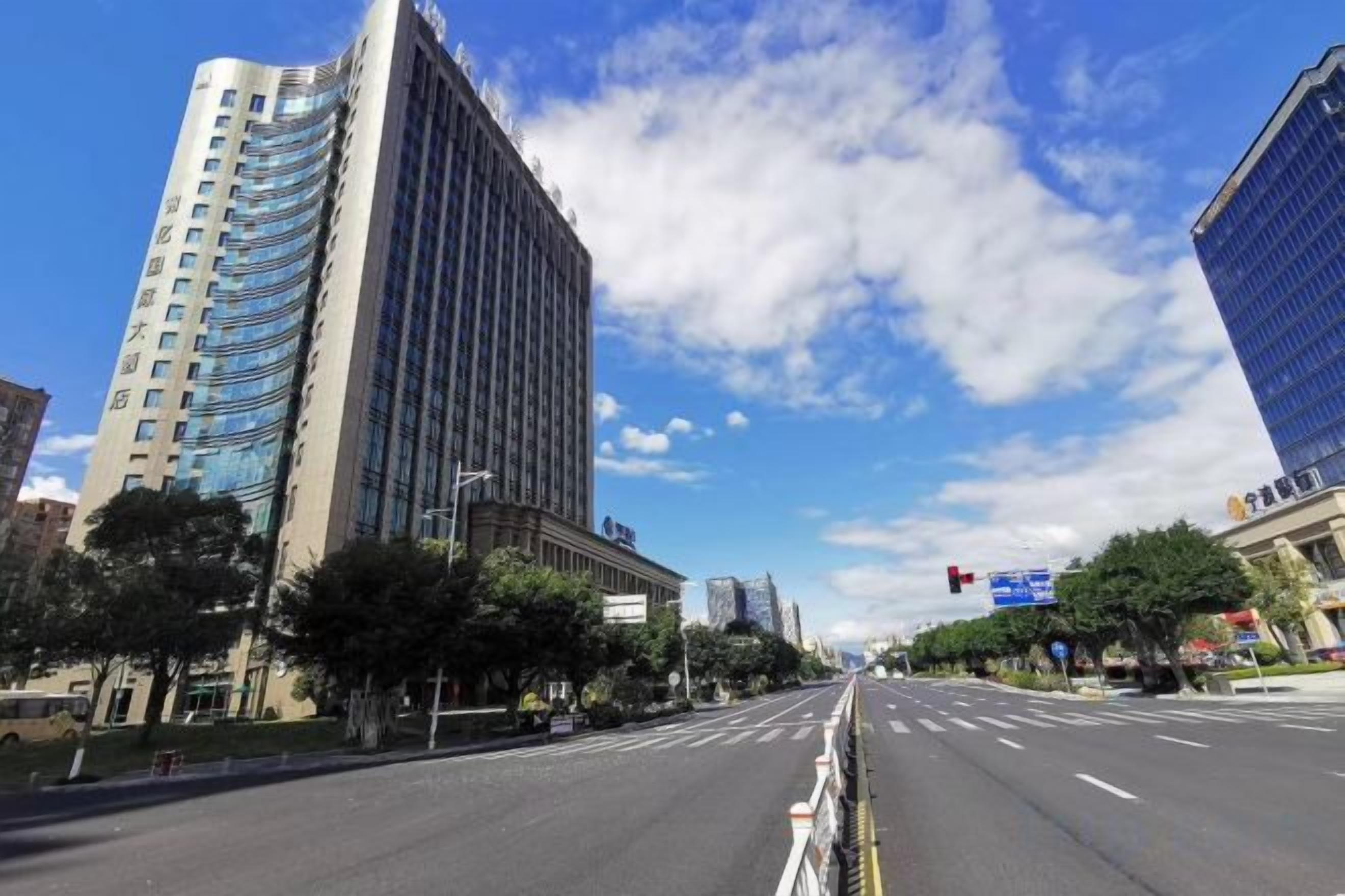A city street with tall buildings, a clear sky, and a crosswalk.