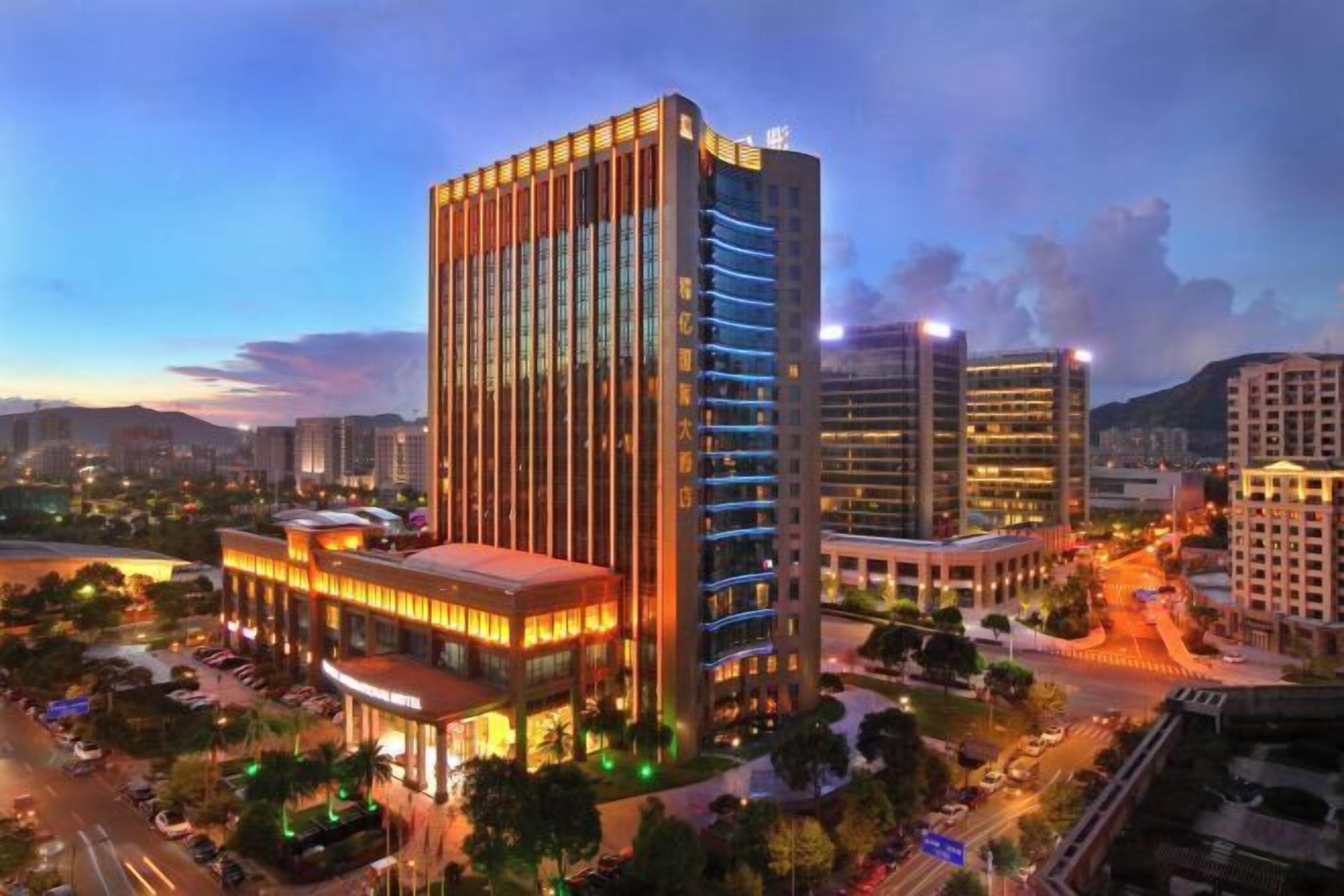 A high-rise hotel with multiple floors, a prominent entrance, and a well-lit facade.