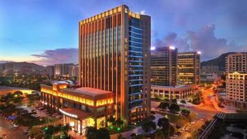 A high-rise hotel with multiple floors, a prominent entrance, and a well-lit facade.