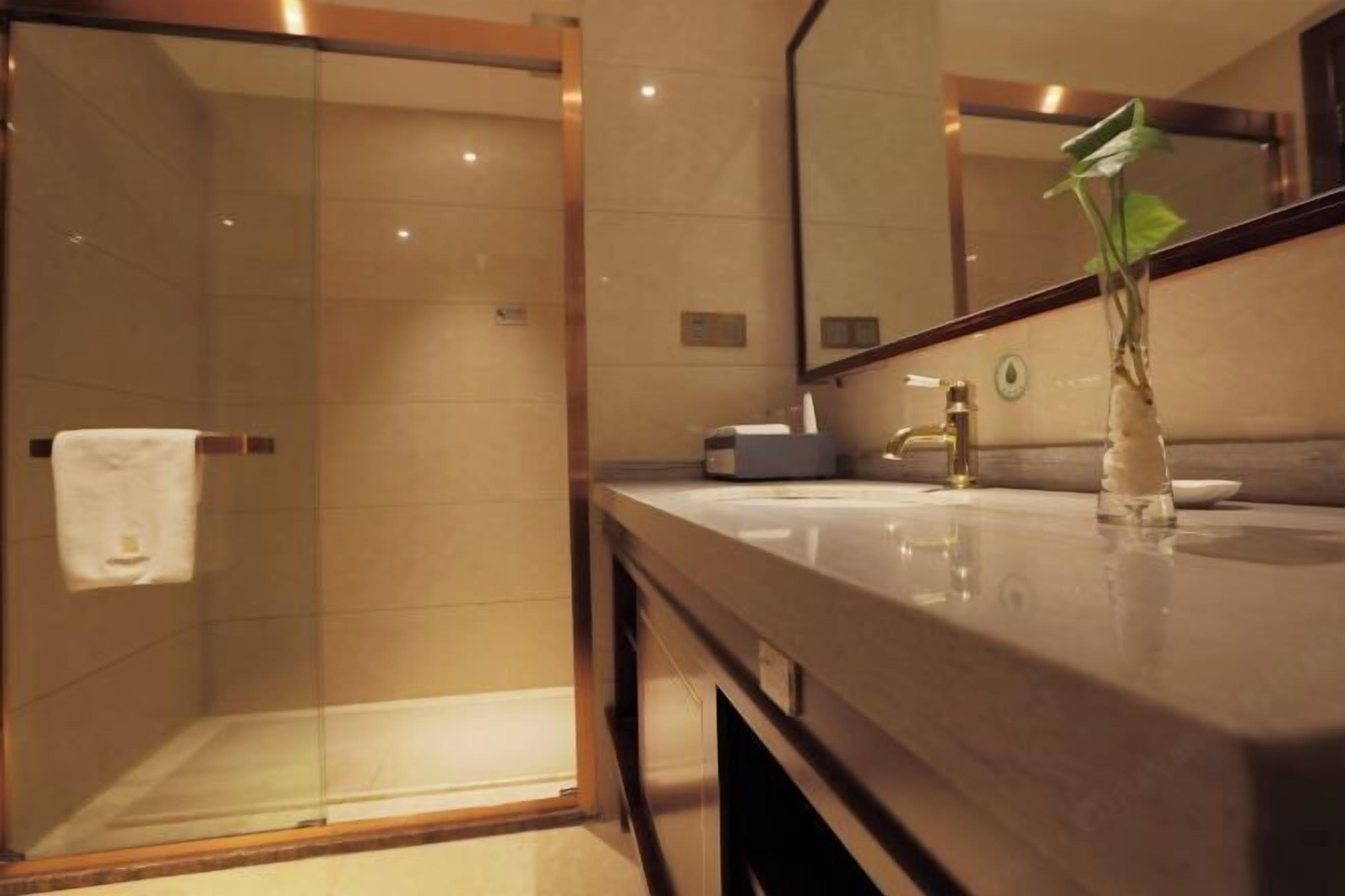 A modern bathroom with a glass-enclosed shower, a wooden vanity, and a mirror.