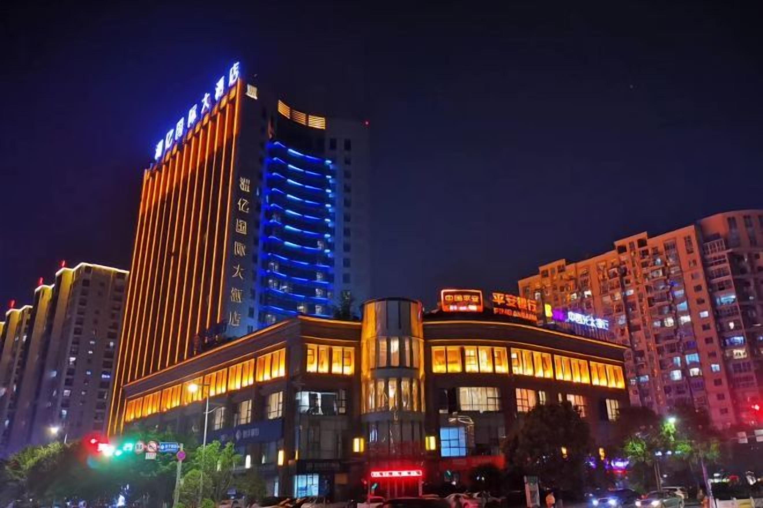 A multi-story hotel with illuminated signage, a prominent entrance, and surrounding high-rise buildings.