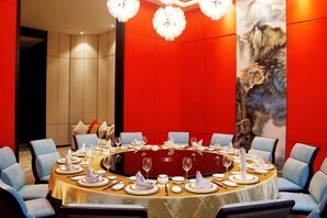 A conference room with a round table set for a meeting, surrounded by chairs. - CHOUERY International Hotel (Wenzhou)
