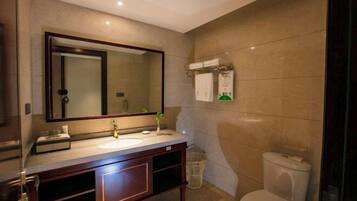 A modern bathroom with a large mirror, a sink, and a toilet.