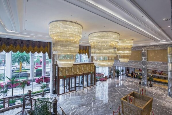A spacious lobby with large chandeliers, a marble floor, and a view of parked cars outside. - CHOUERY International Hotel (Wenzhou)