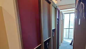 A corridor with multiple seating areas, each with a bench and a small table. - Guest house Blue Ocean Naha - Hostel  (Naha)