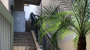A staircase with stone steps and black metal railings, leading to a building entrance. - Guest house Blue Ocean Naha - Hostel  (Naha)