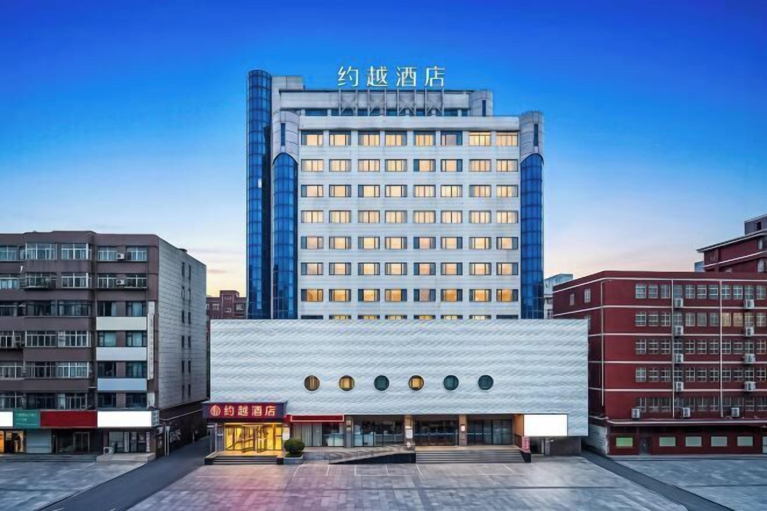Un hotel con una facciata moderna, diversi piani e un ingresso ben visibile con tetto piatto.