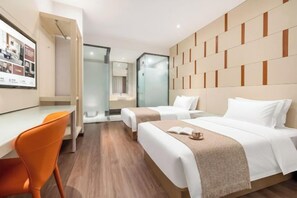 Une chambre d’hôtel avec deux lits, un bureau et une chaise.