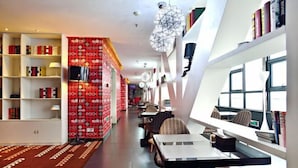 A modern hotel lobby with a central seating area, bookshelves, and a patterned carpet. - Yue Yue Scenic View Hotel(Zhengzhou Boudou·Xinxiang Confucius Temple Metro Station Store) (Zhengzhou)