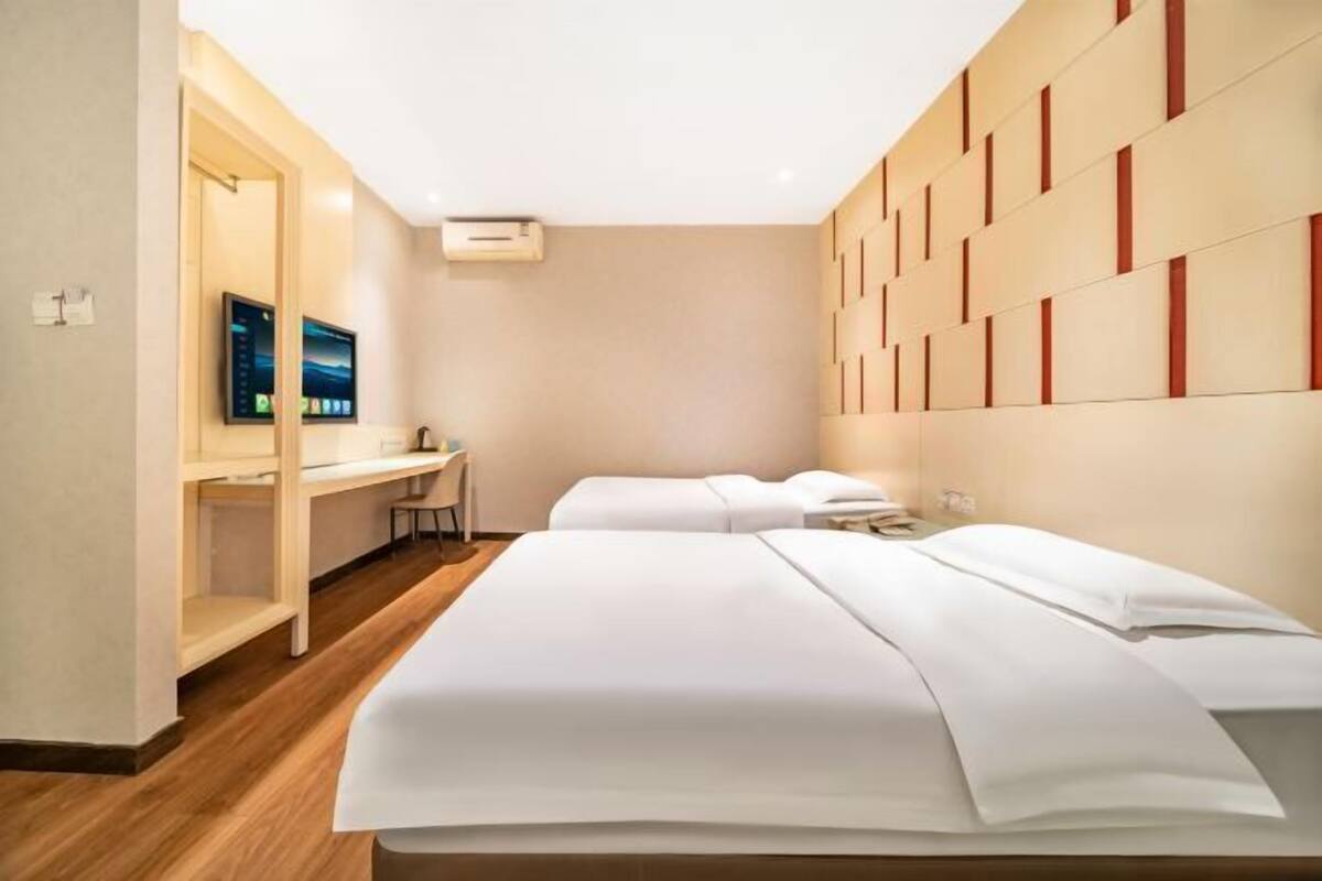 Una habitación de hotel con una cama, un escritorio, una silla y un televisor.