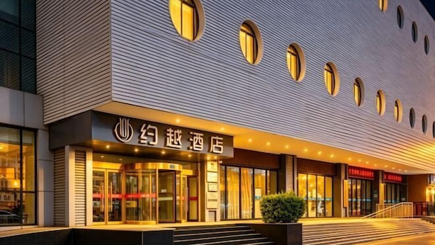 A hotel entrance with a modern facade, large glass doors, and a staircase leading up to the entrance. - Yue Yue Scenic View Hotel(Zhengzhou Boudou·Xinxiang Confucius Temple Metro Station Store) (Zhengzhou)