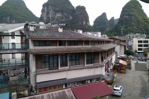 A multi-story building with a traditional architectural style, featuring a tiled roof and large windows. - Bilian Home Inn (Yangshuo West Street) (Yangshuo)