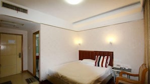 Ein Hotelzimmer mit Bett, Schreibtisch, Stuhl und Tür.