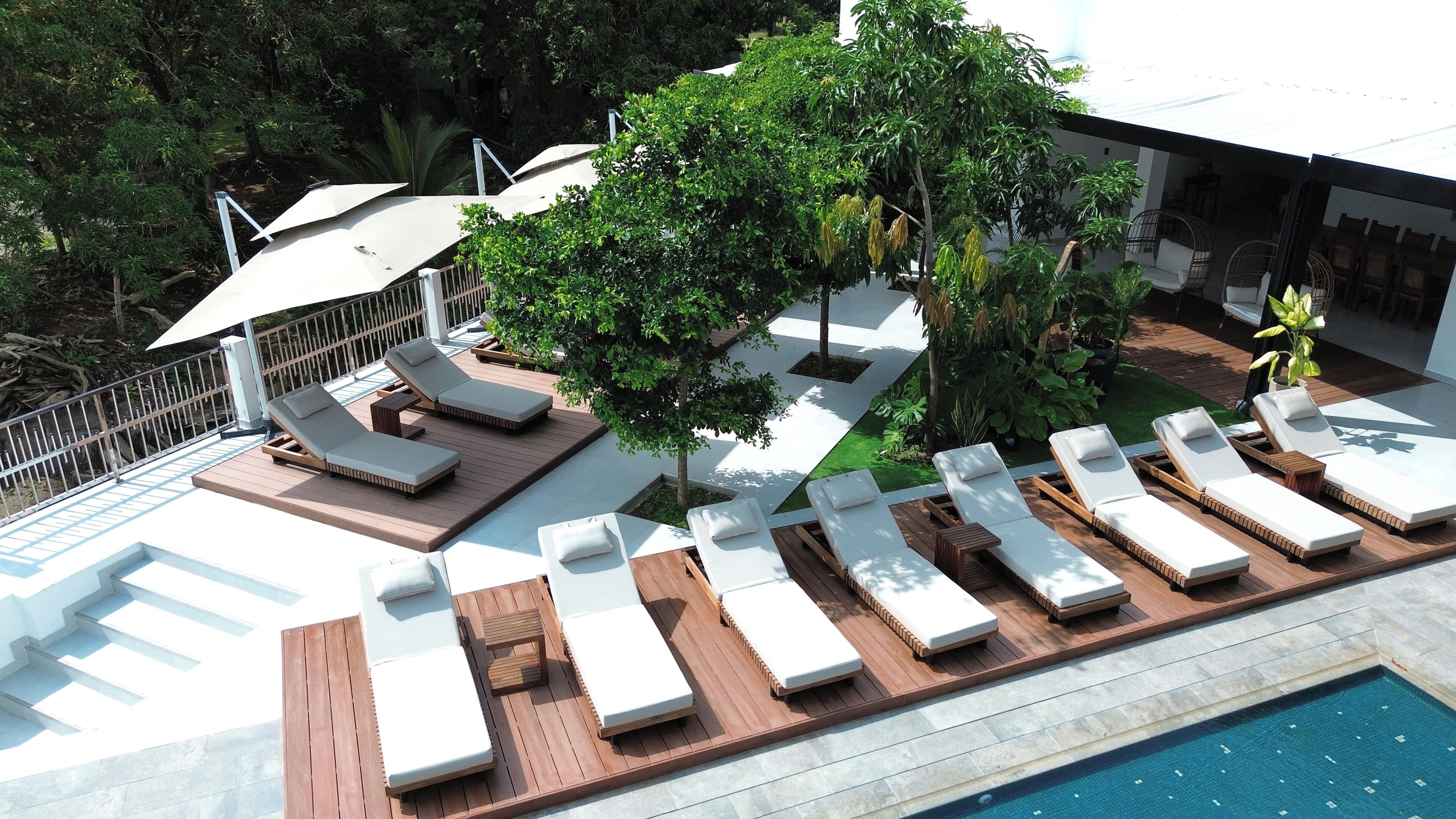 Una piscina al aire libre, sombrillas, tumbonas