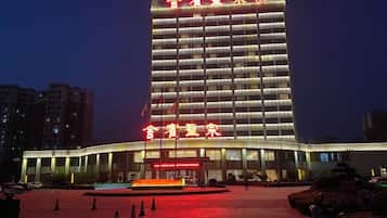 Un hotel moderno de gran altura con una entrada destacada y una fachada bien iluminada.