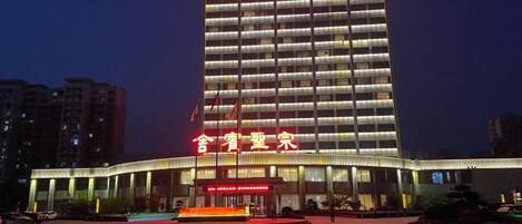A high-rise hotel with a prominent entrance and a well-lit facade.