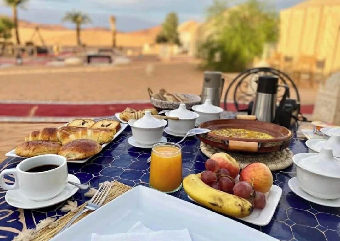 Ett frukostbord med bakverk, frukt, kaffe och en skål soppa.