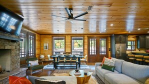 A spacious living room with a fireplace, a dining area, and a kitchen.