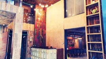 A modern interior with a reception desk, a staircase, and a bar area.