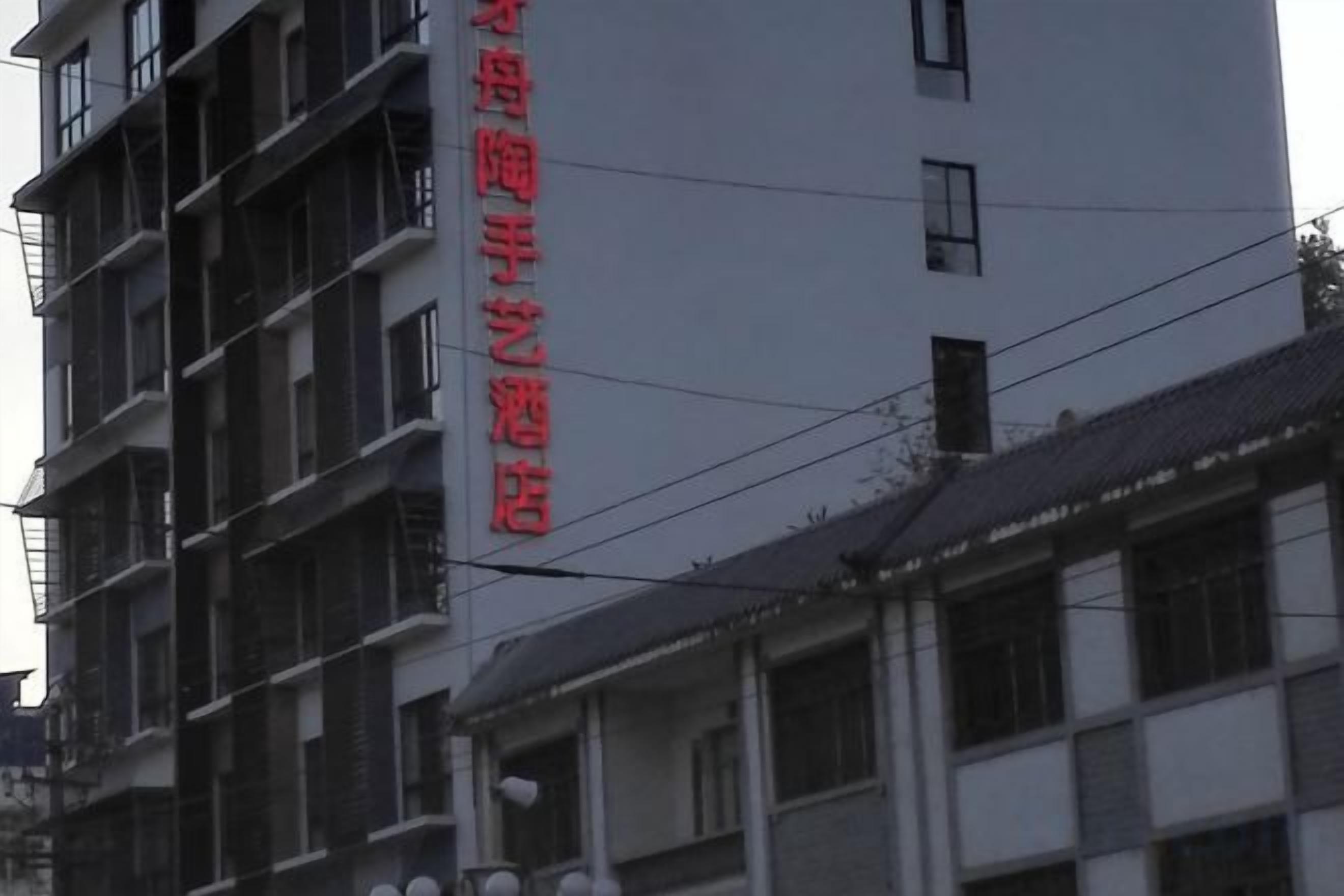 A multi-story building with a prominent red sign on the facade.