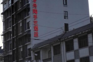 Ein mehrstöckiges Gebäude mit einem auffälligen, roten Schild an der Fassade.